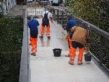 4 Männer arbeiten auf einem Fußgängersteg